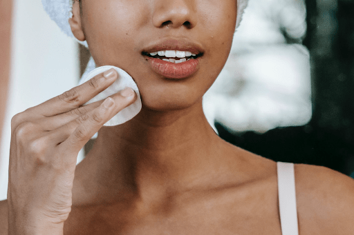 A woman cleansing her face who has started anti-aging treatments.
